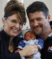 In this April 23, 2008, file photo, Alaska Governor Sarah Palin and her husband Todd Palin hold their baby boy, Trig, in Anchorage, Alaska.  Palin's fifth child was born April 18 with Down syndrome, a genetic abnormality that impedes physical, intellectual and language development. (AP Photo/Al Grillo, File)